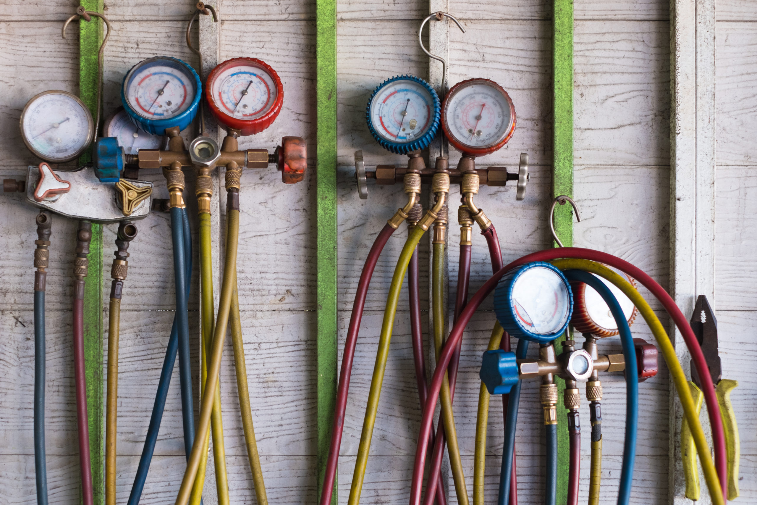 Pressure gauge on the air compressor to measure liquid air pressure for the car air compressor on the wall in garage. diagnostic climatisation
